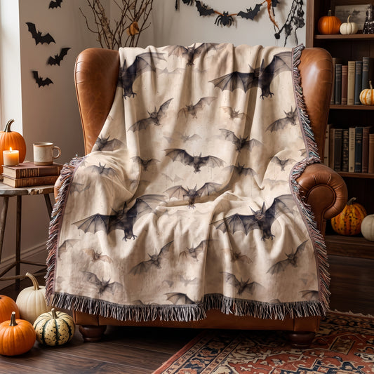 Vintage bat Halloween woven blanket draped over a cognac leather armchair in a cozy reading nook