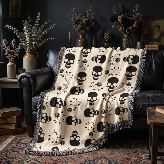 Black skull woven blanket draped over a black leather sofa in a moody living room