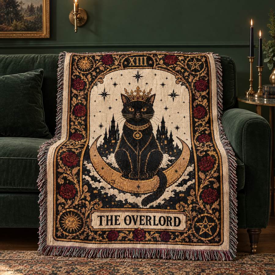 The Overlord black cat tarot woven blanket draped over a green velvet sofa with candles