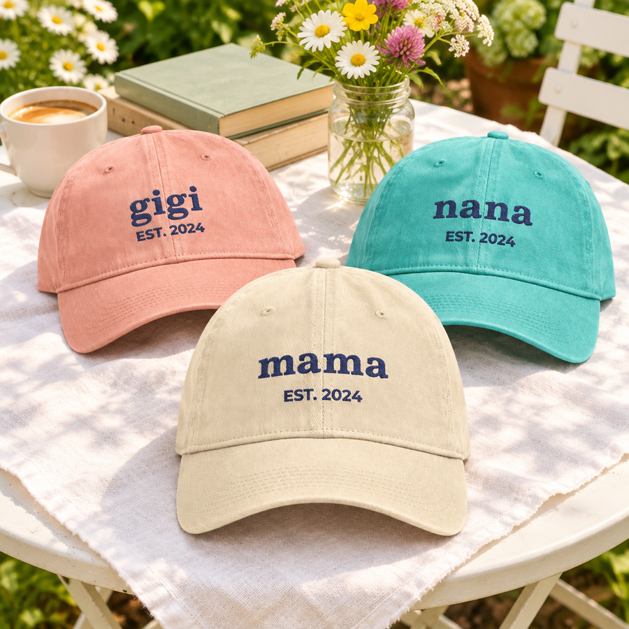 Custom embroidered mama, gigi and nana hats on a sunny patio table