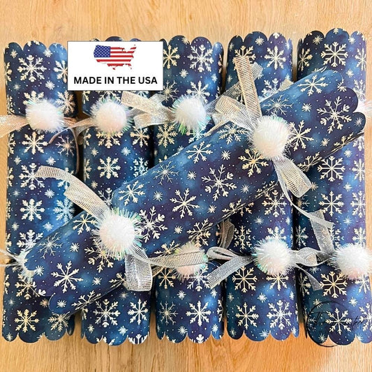 Blue snowflake crackers stacked to show the scalloped ends and white pom poms