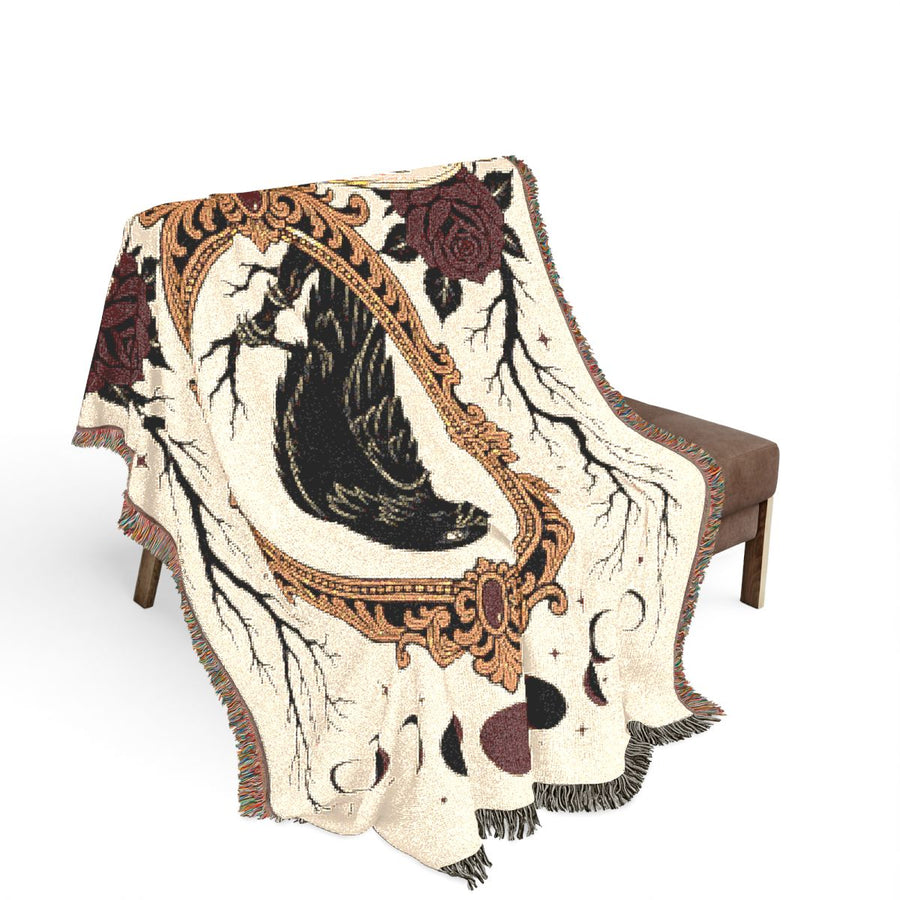 Emotional Support Raven woven blanket draped over a wooden chair on a white background