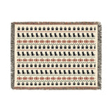 Halloween woven blanket draped over a chair in bone and rust tones