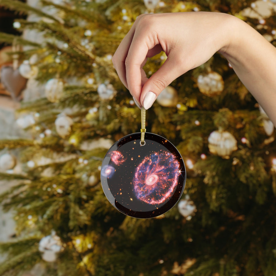 James Webb Cartwheel Galaxy glass Christmas ornament held in hand