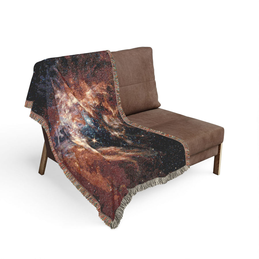 Tarantula Nebula woven blanket spread across a bed as a space bedspread