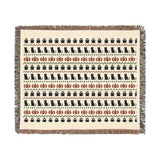 Fair Isle Halloween throw blanket draped on a sofa in neutral bone, charcoal and rust