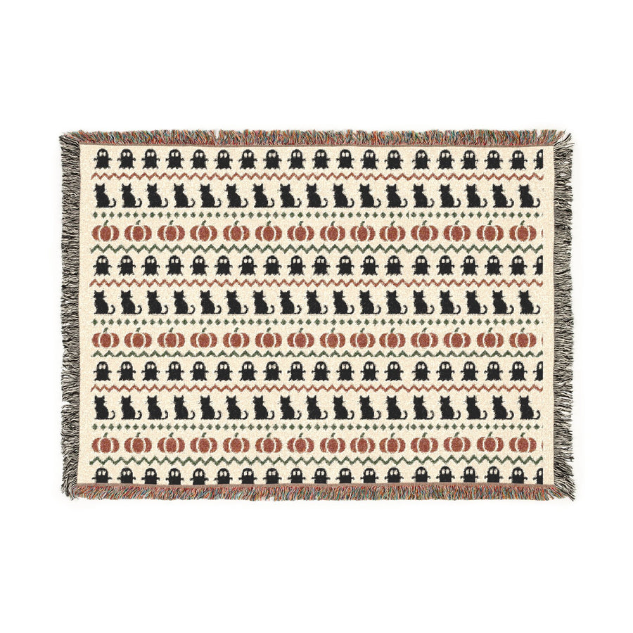 Neutral Halloween woven blanket with Fair Isle rows of ghosts, black cats and pumpkins in bone and rust