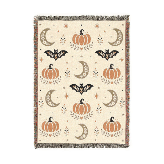 Neutral Halloween woven blanket spread across a bed for autumn decor