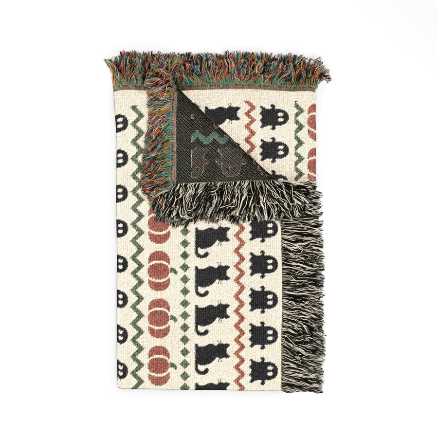 Boho Halloween woven throw shown flat, banded ghost cat and pumpkin pattern