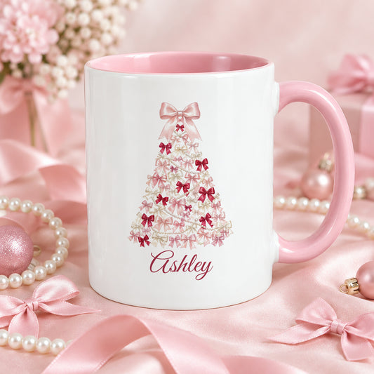 Close-up of the coquette bow Christmas tree mug with the name Ashley, pink handle, with pink ribbons, satin bows and pearls