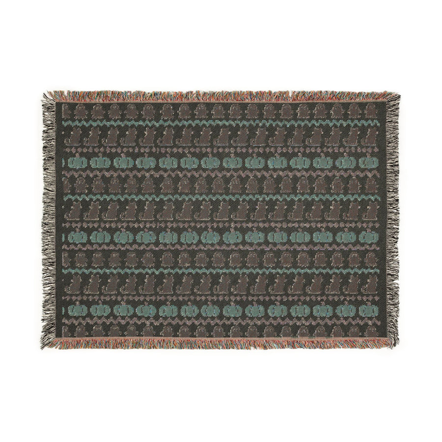 Neutral Halloween blanket hung on a wall as a Fair Isle tapestry