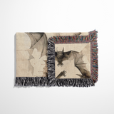 Folded bat woven blanket on a bench, showing the reversible jacquard weave