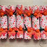 Thanksgiving crackers trimmed with autumn leaves and ribbon on a set table