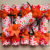 Thanksgiving crackers in orange pumpkin tones, handmade dinner party favours in a row
