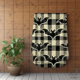 Bat plaid Halloween blanket hung on a wall rail against wood panelling