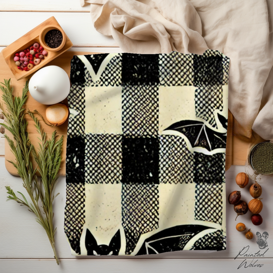 Close view of the bat plaid fleece on a table with herbs, showing the soft pile and check scale