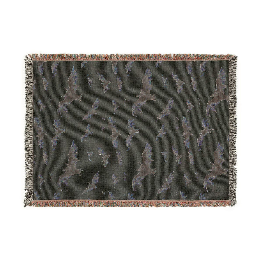 Reverse side of the bat woven blanket in dark charcoal with the bat pattern