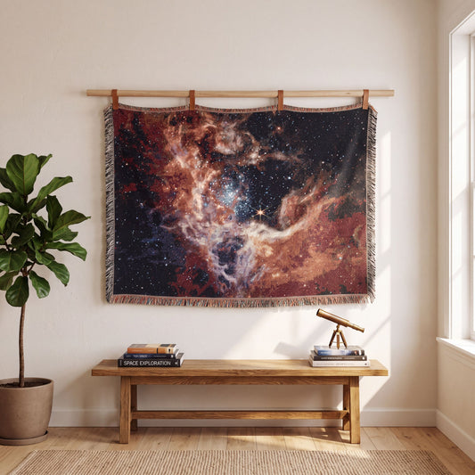 Tarantula Nebula woven blanket hanging straight from a wooden dowel above an oak bench with a brass telescope, James Webb space tapestry