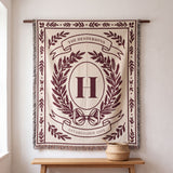 Burgundy personalized family crest woven blanket hanging on a wall