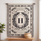 Black personalized family crest woven blanket hanging on a wall