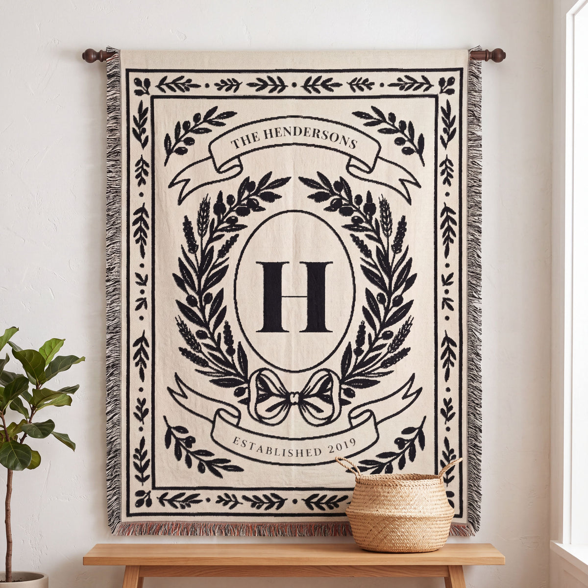 Black personalized family crest woven blanket hanging on a wall