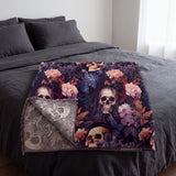 Skull and flowers woven blanket folded on a bed with the reverse side showing