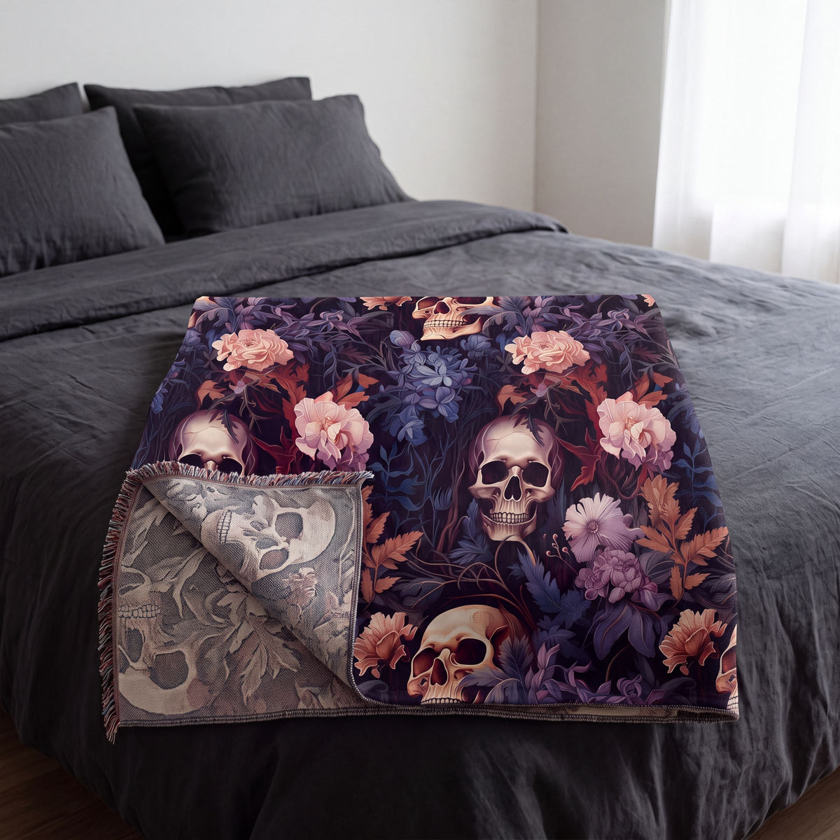 Skull and flowers woven blanket folded on a bed with the reverse side showing