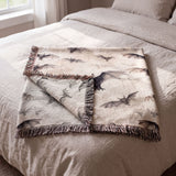 Bat woven blanket folded on a bed with the reverse side showing