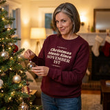 Woman hanging an ornament on the tree in the Maroon funny Christmas music sweatshirt