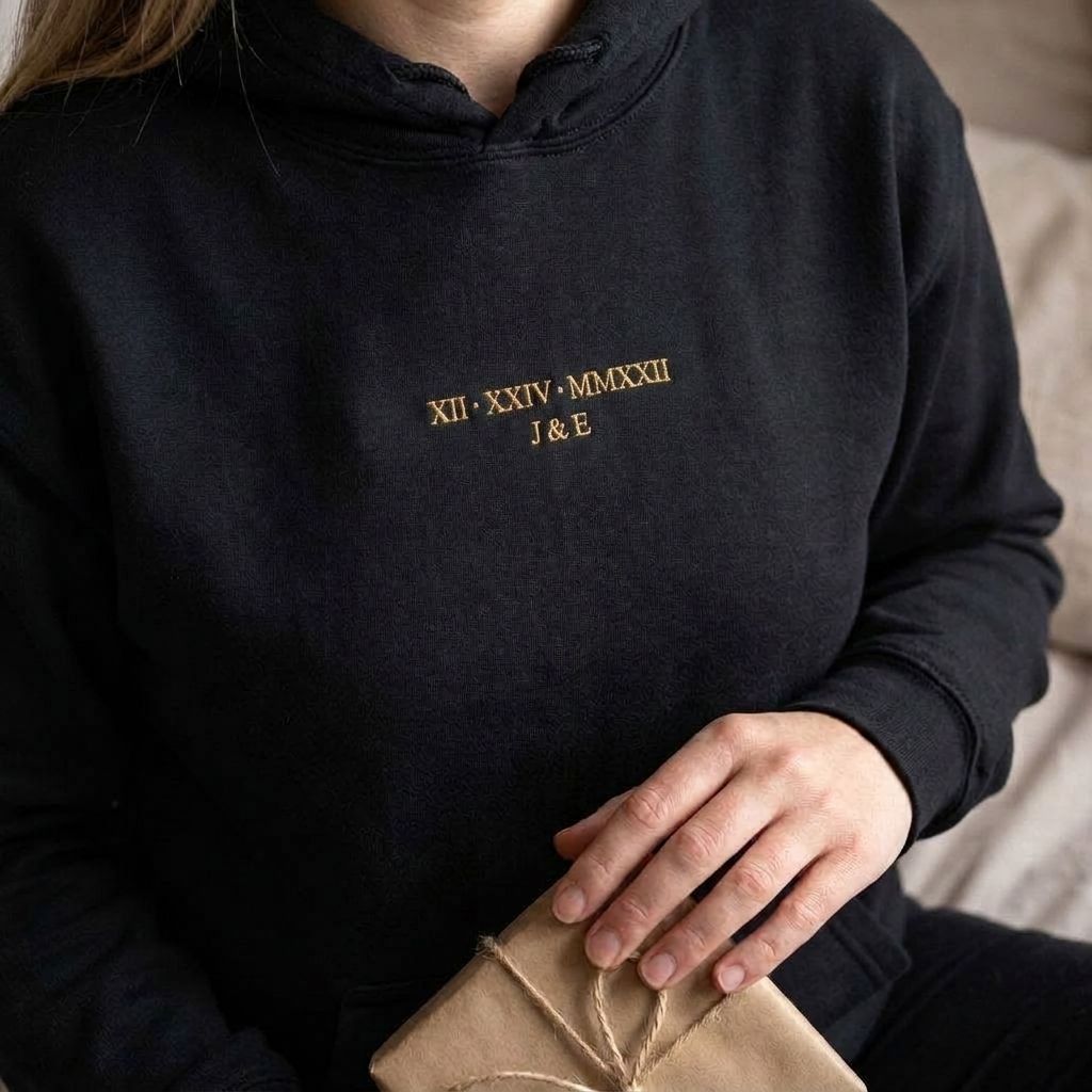 Black Roman numeral hoodie with XII XXIV MMXXII and J & E embroidered in old gold thread