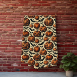 Pumpkin and bat Halloween blanket hung against a red brick wall