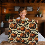 Child holding up the pumpkin and bat Halloween blanket in a wood panelled bedroom