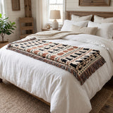 Haunted Heirloom Fair Isle ghost and black cat woven blanket folded across the foot of a queen bed