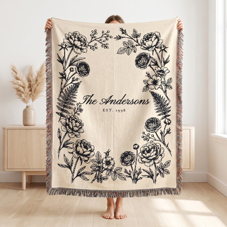 Black family name woven blanket held up to show the 60 x 80 size