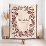 Burgundy family name woven blanket held up to show the 60 x 80 size