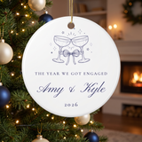 Personalized The Year We Got Engaged ornament with champagne toast design hanging on a Christmas tree