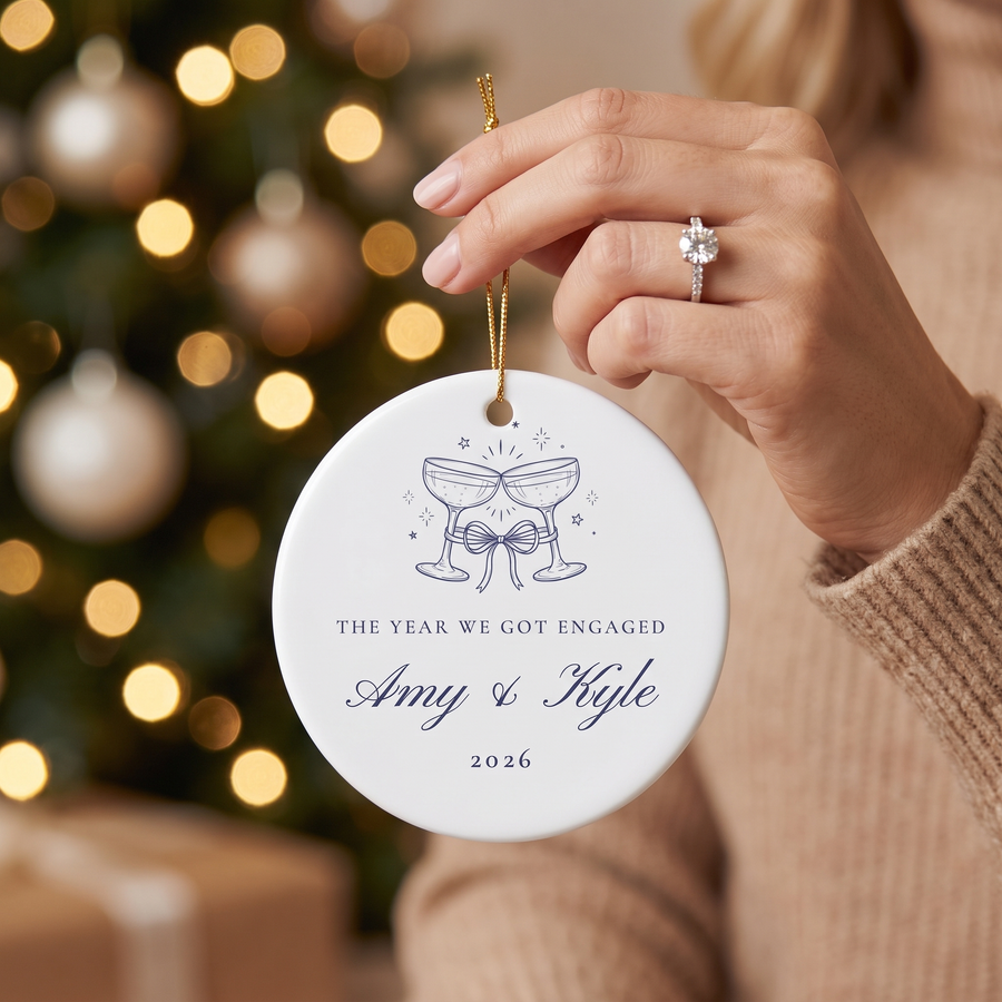 Hand with engagement ring holding the personalized champagne toast ornament