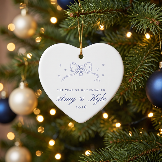 Personalized heart engagement ornament with ribbon bow and ring hanging on a Christmas tree