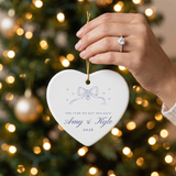 Hand with engagement ring holding the heart ribbon bow ornament