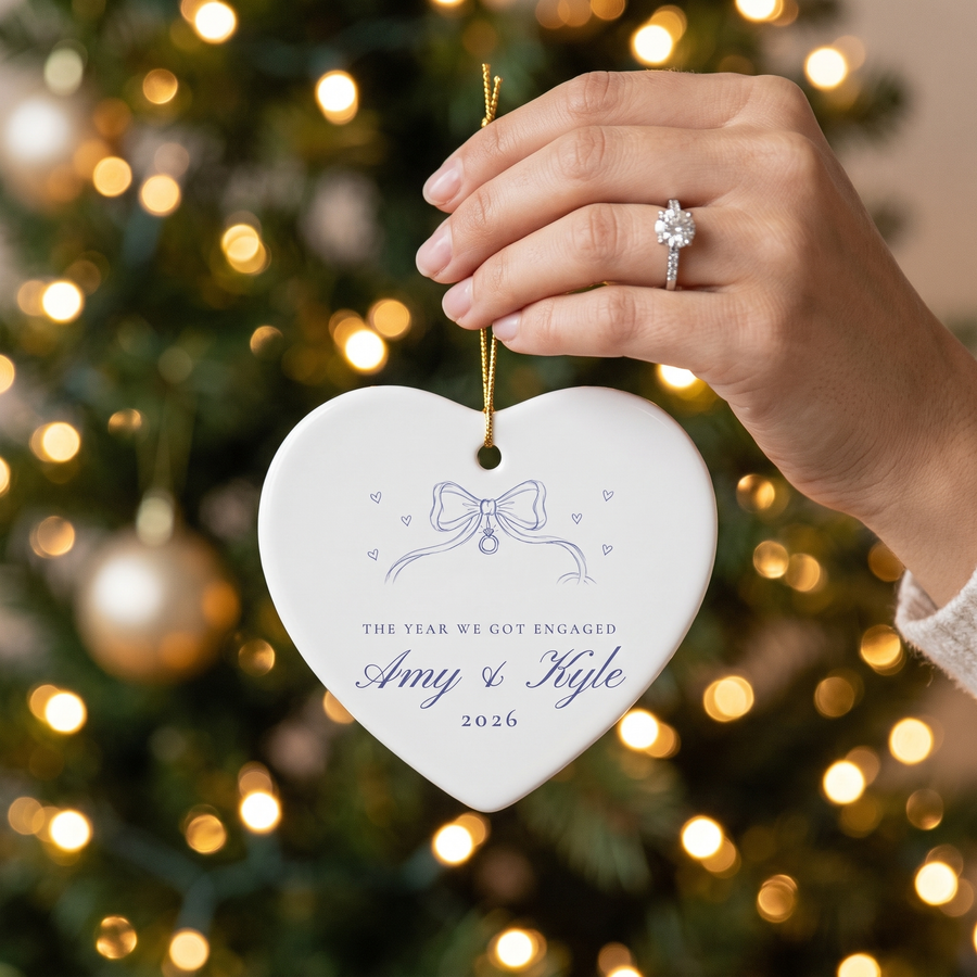 Hand with engagement ring holding the heart ribbon bow ornament