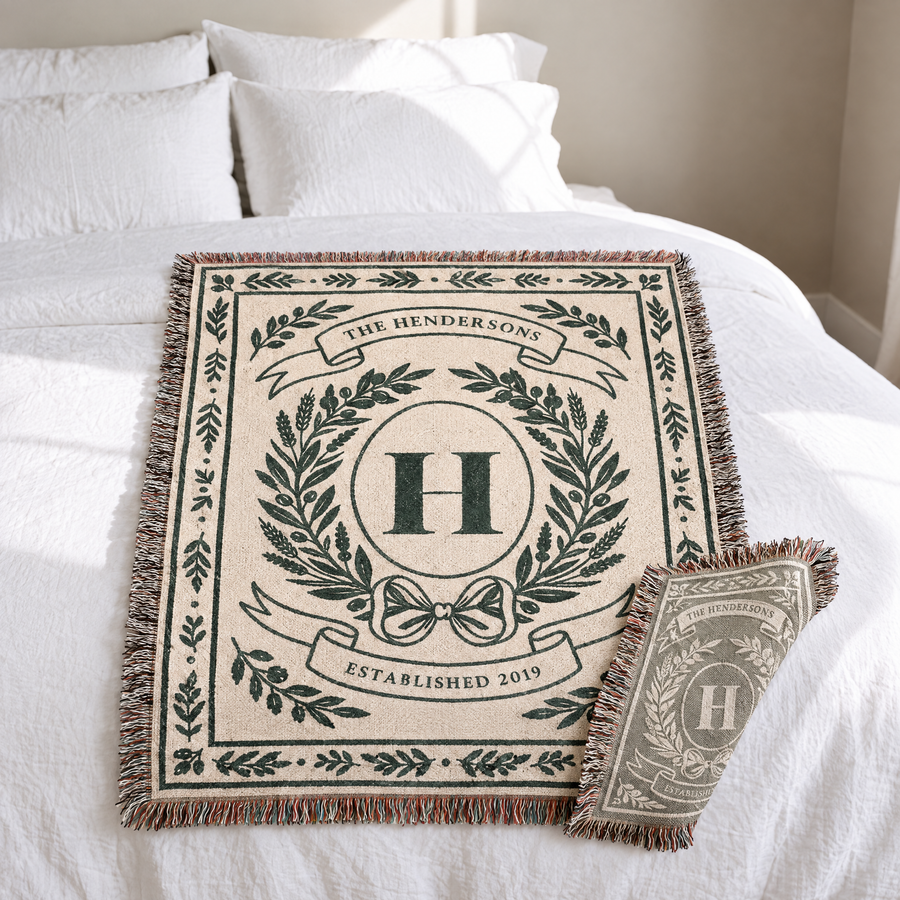 Personalized family crest woven blanket folded on a bed with the reverse side showing