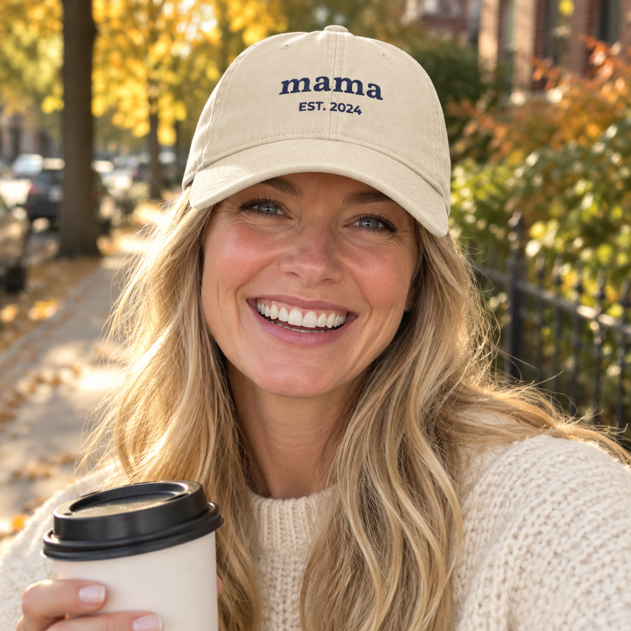 Woman wearing the ivory embroidered mama hat with EST year
