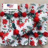 Close view of the red poinsettia and pine print with a red tinsel pom pom