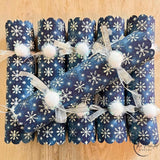 Close view of the snowflake print on deep navy paper with a white pom pom