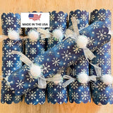 Blue snowflake crackers stacked to show the scalloped ends and white pom poms