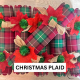 The Christmas Plaid design named on the photo, red and green tartan crackers with green pom poms
