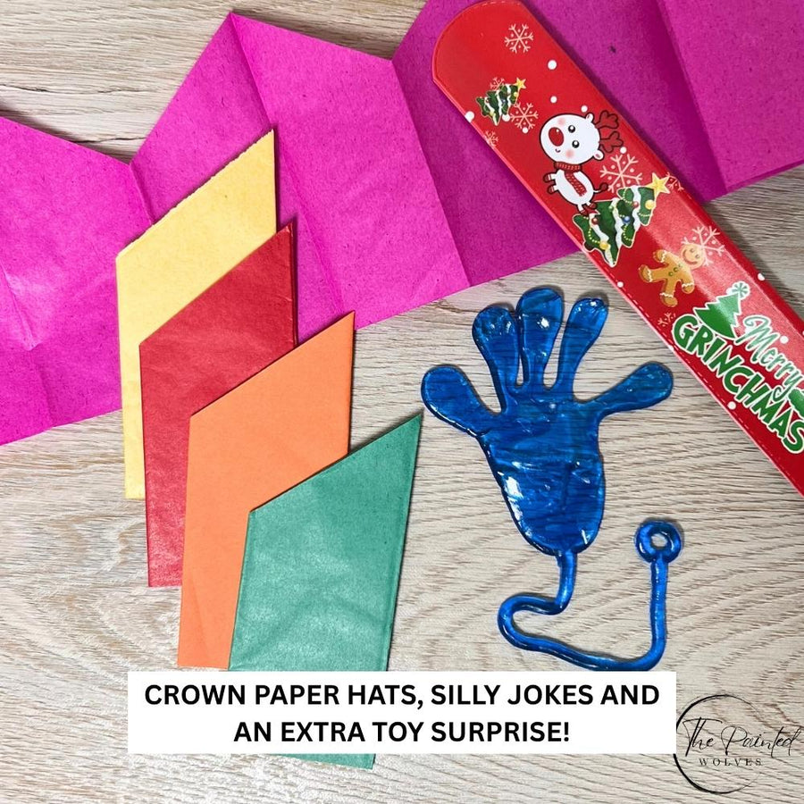 Folded paper party hats, a joke slip and a sticky hand toy taken out of the crackers