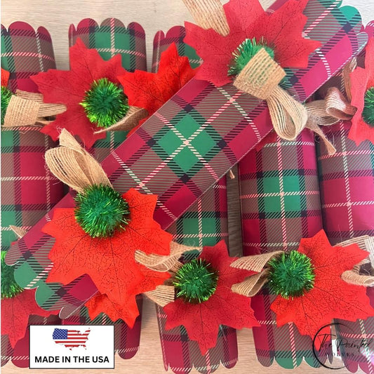 Six red and green plaid Christmas crackers tied with burlap bows, red leaves and green pom poms