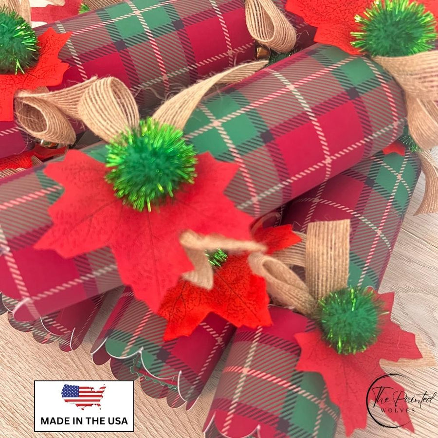 Close view of plaid Christmas crackers showing the red fabric leaf and green tinsel pom pom