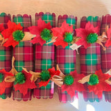 Set of six plaid Christmas crackers laid in a row ready for the dinner table